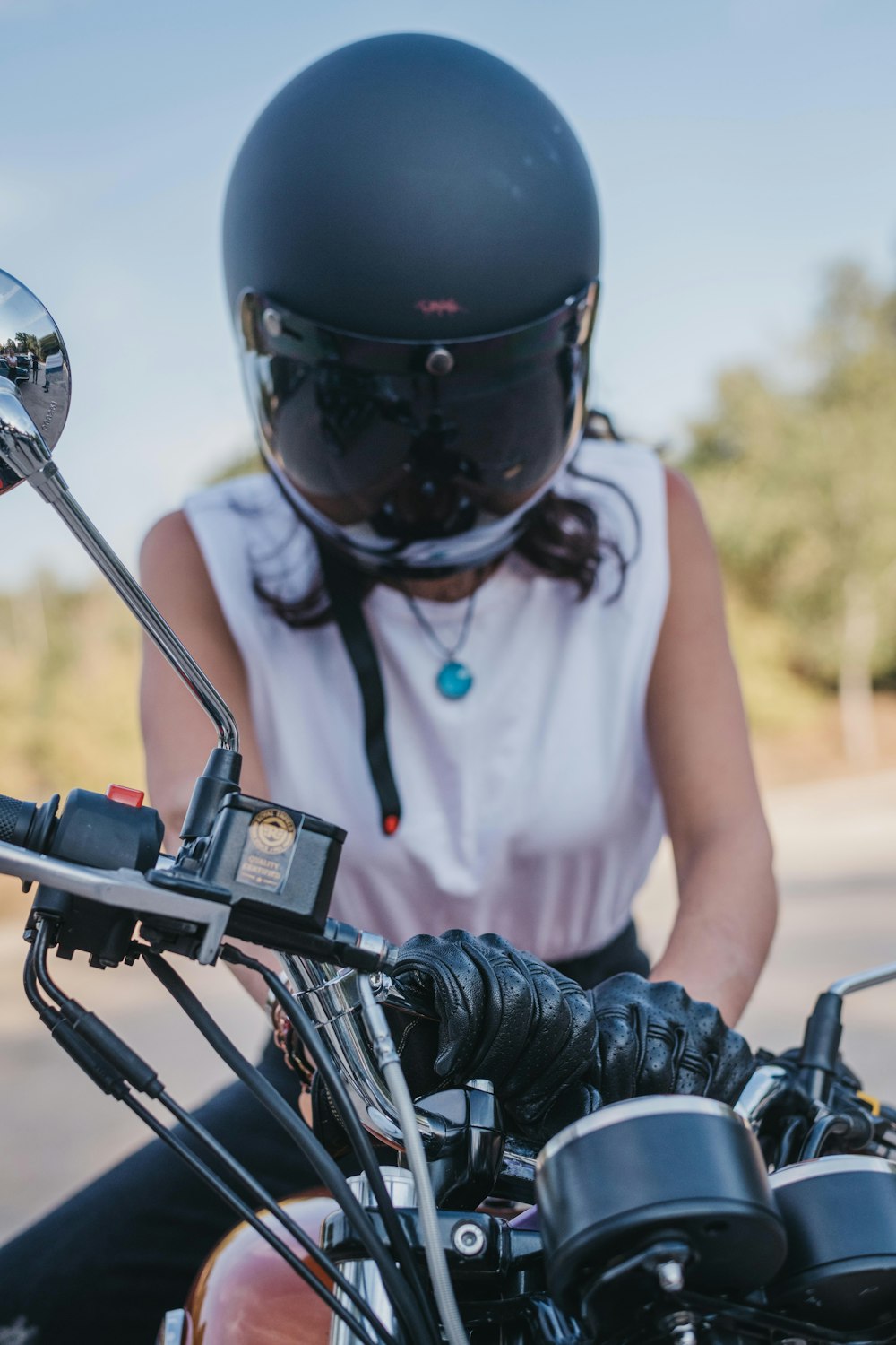 a woman wearing a helmet sitting on a motorcycle