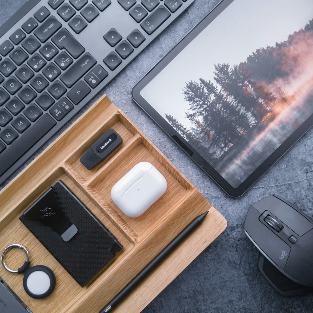 a desk with a laptop, mouse, keyboard, and other items