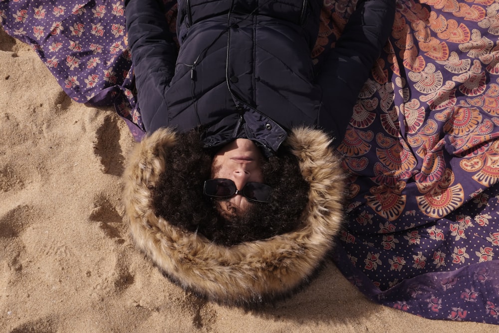 a person laying on top of a blanket on a beach