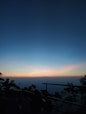 a person sitting on a bench watching the sunset