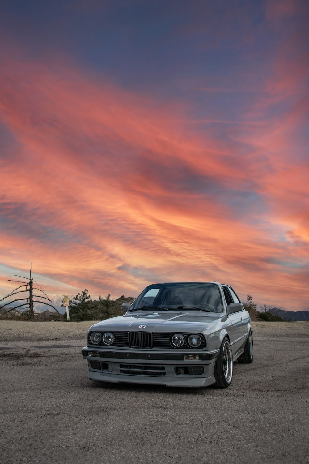 a car parked in a parking lot with a sunset in the background