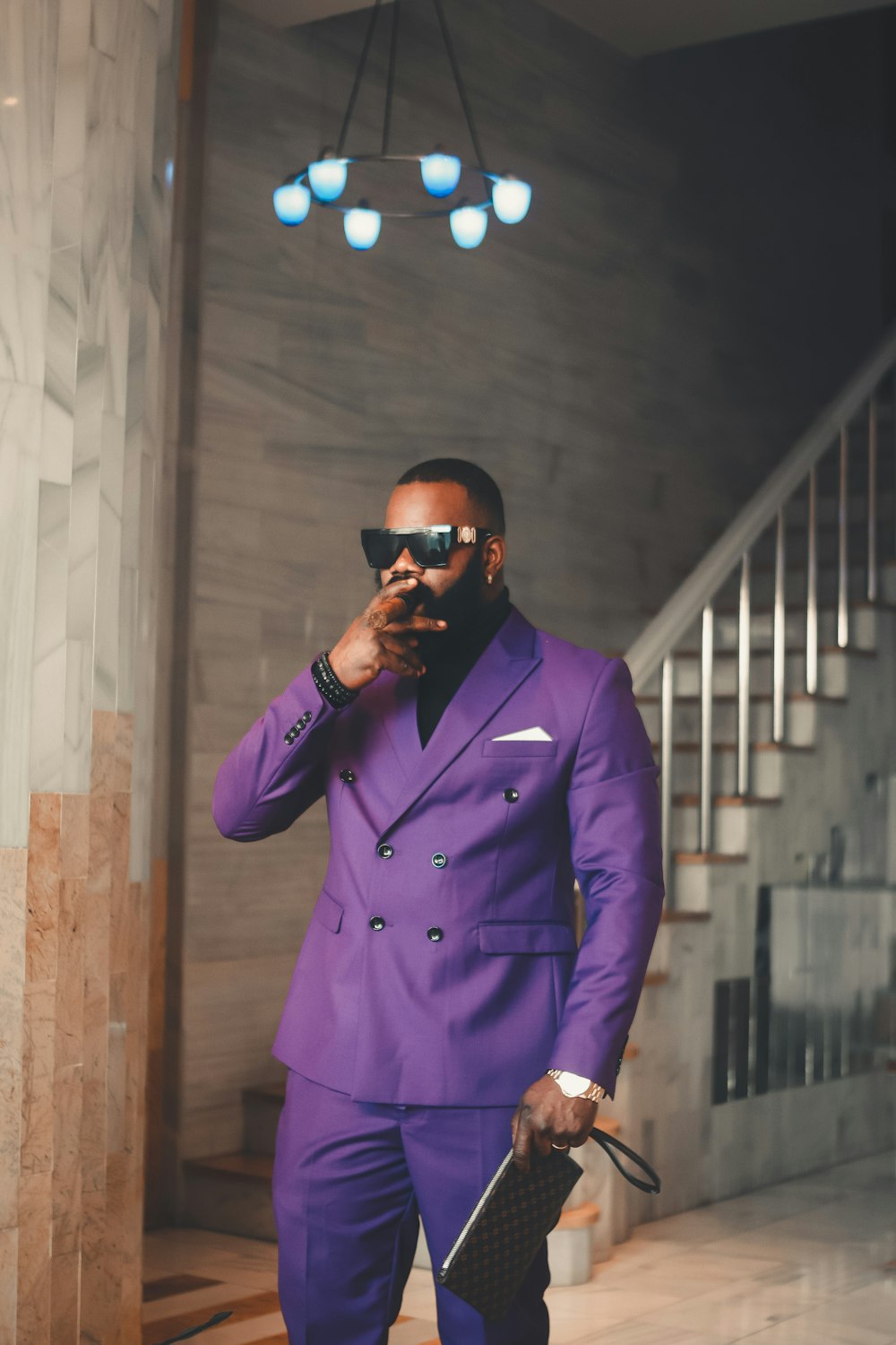 a man in a purple suit holding a cell phone