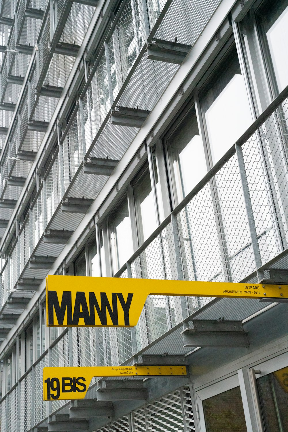 a yellow street sign hanging from the side of a building