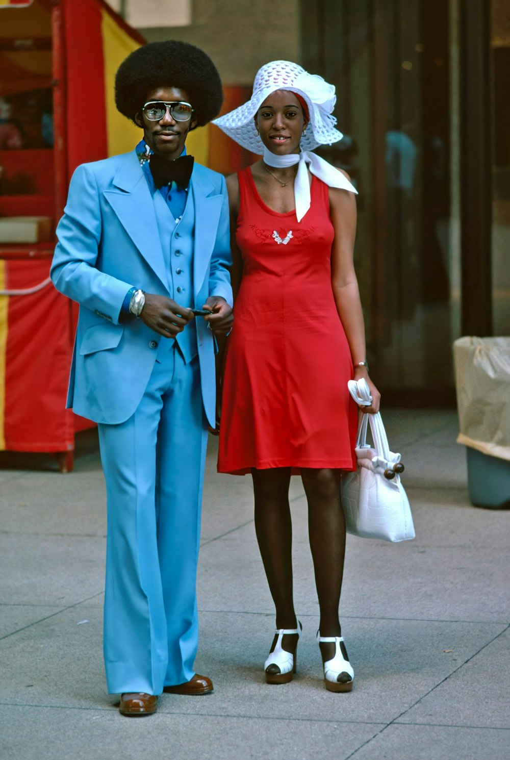 um homem e uma mulher vestidos de azul e vermelho