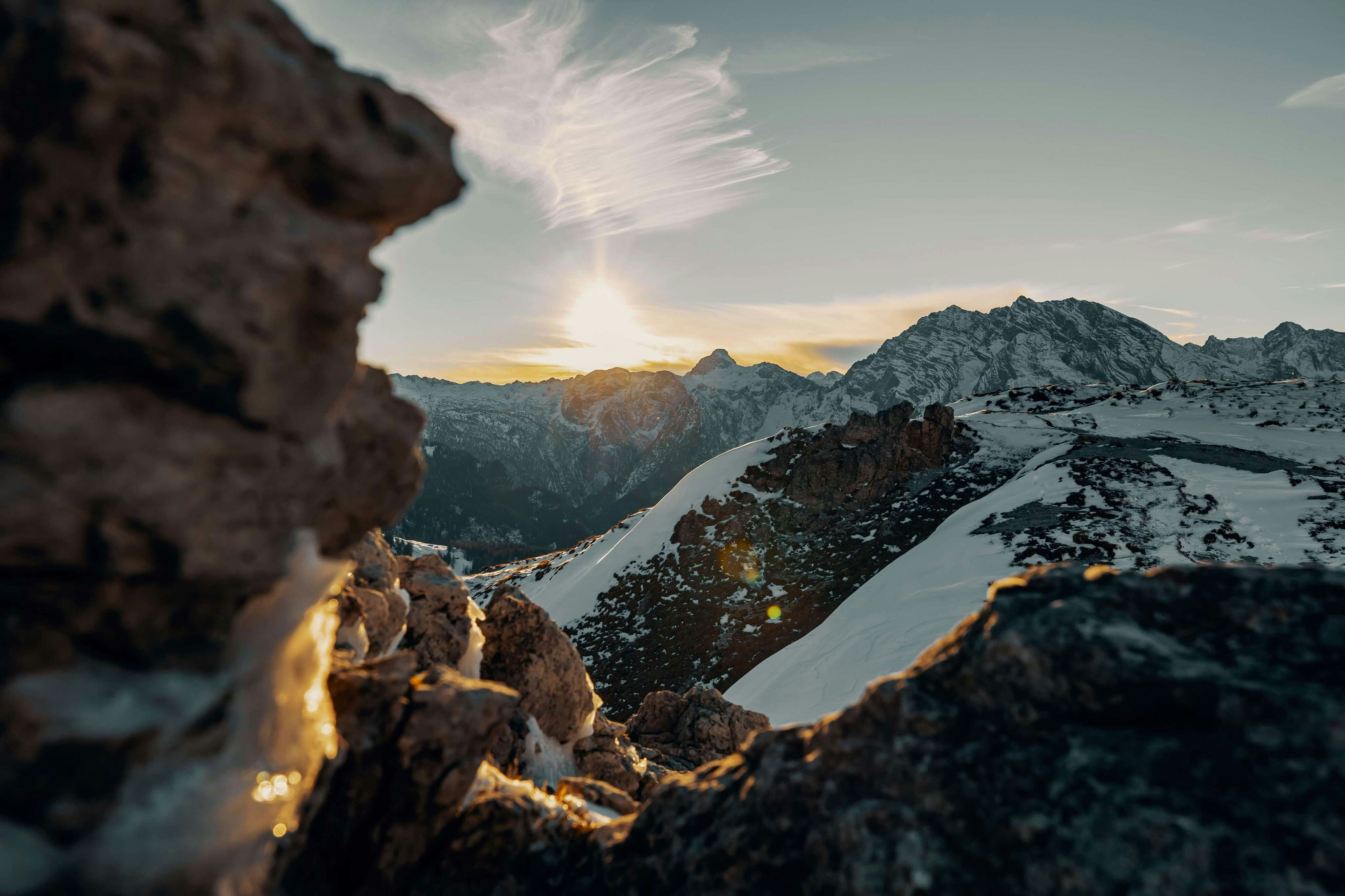 the sun is setting over a mountain range
