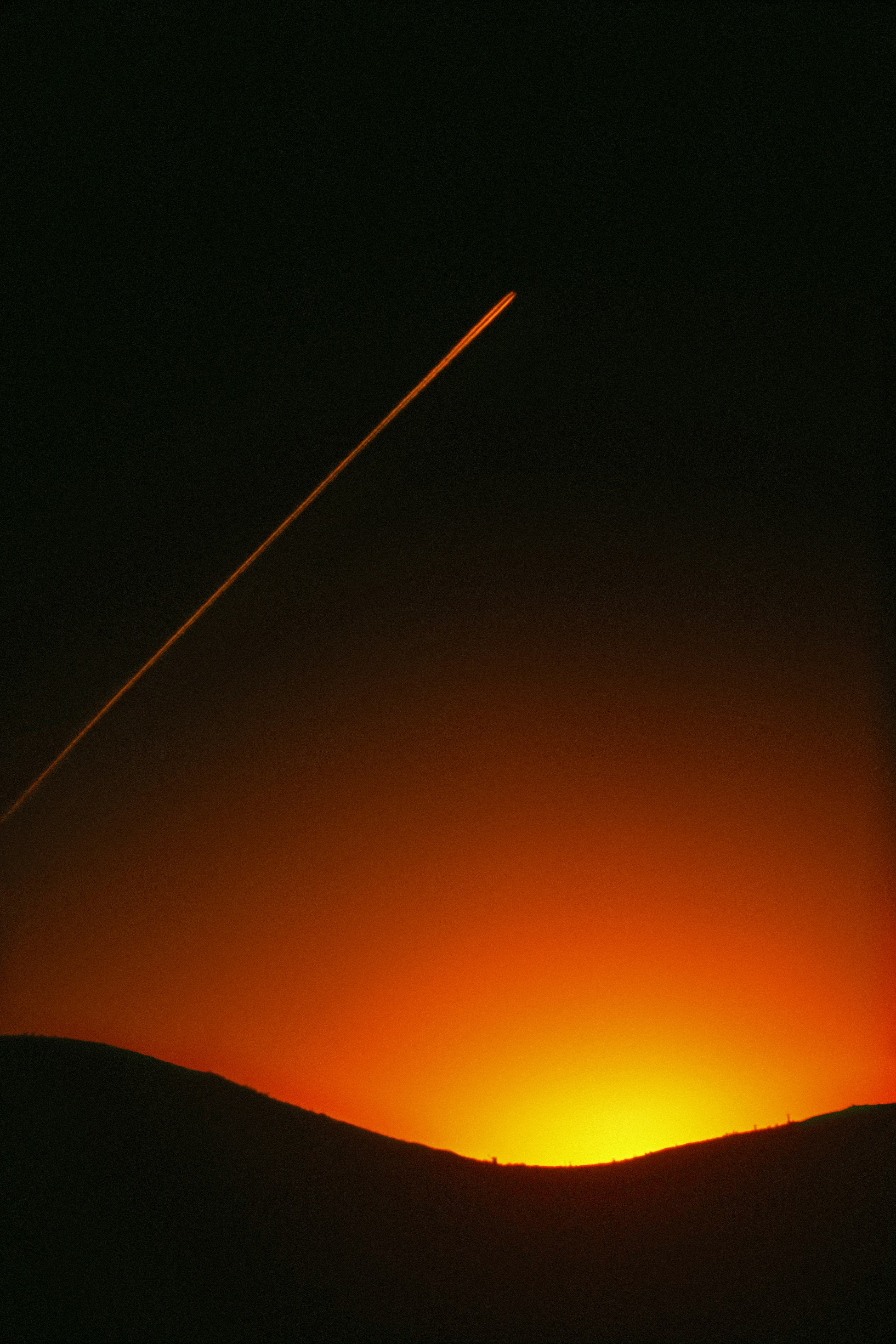 um avião está voando no céu ao pôr do sol