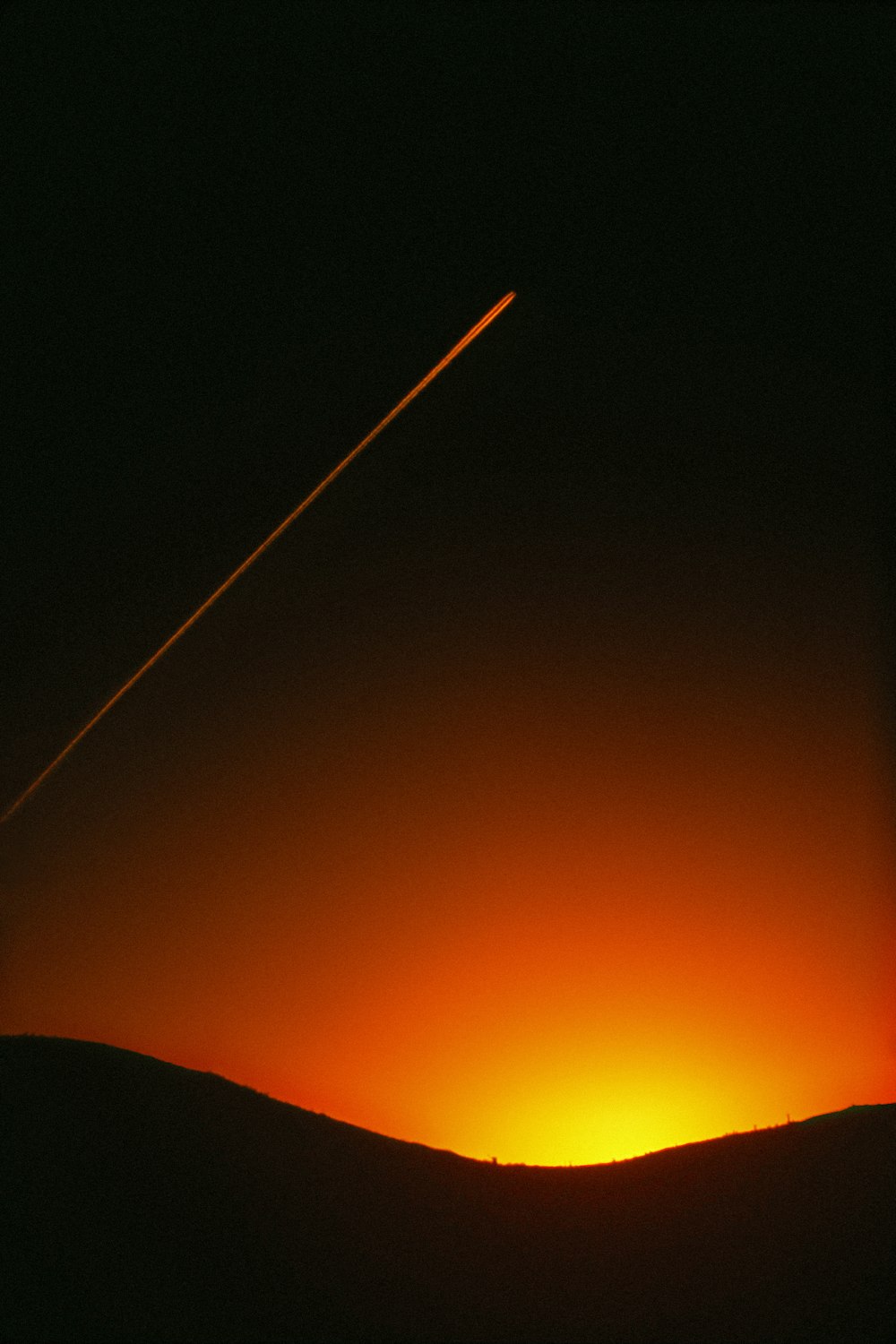 a plane is flying in the sky at sunset