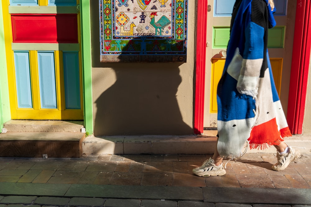 a person standing in front of a colorful building