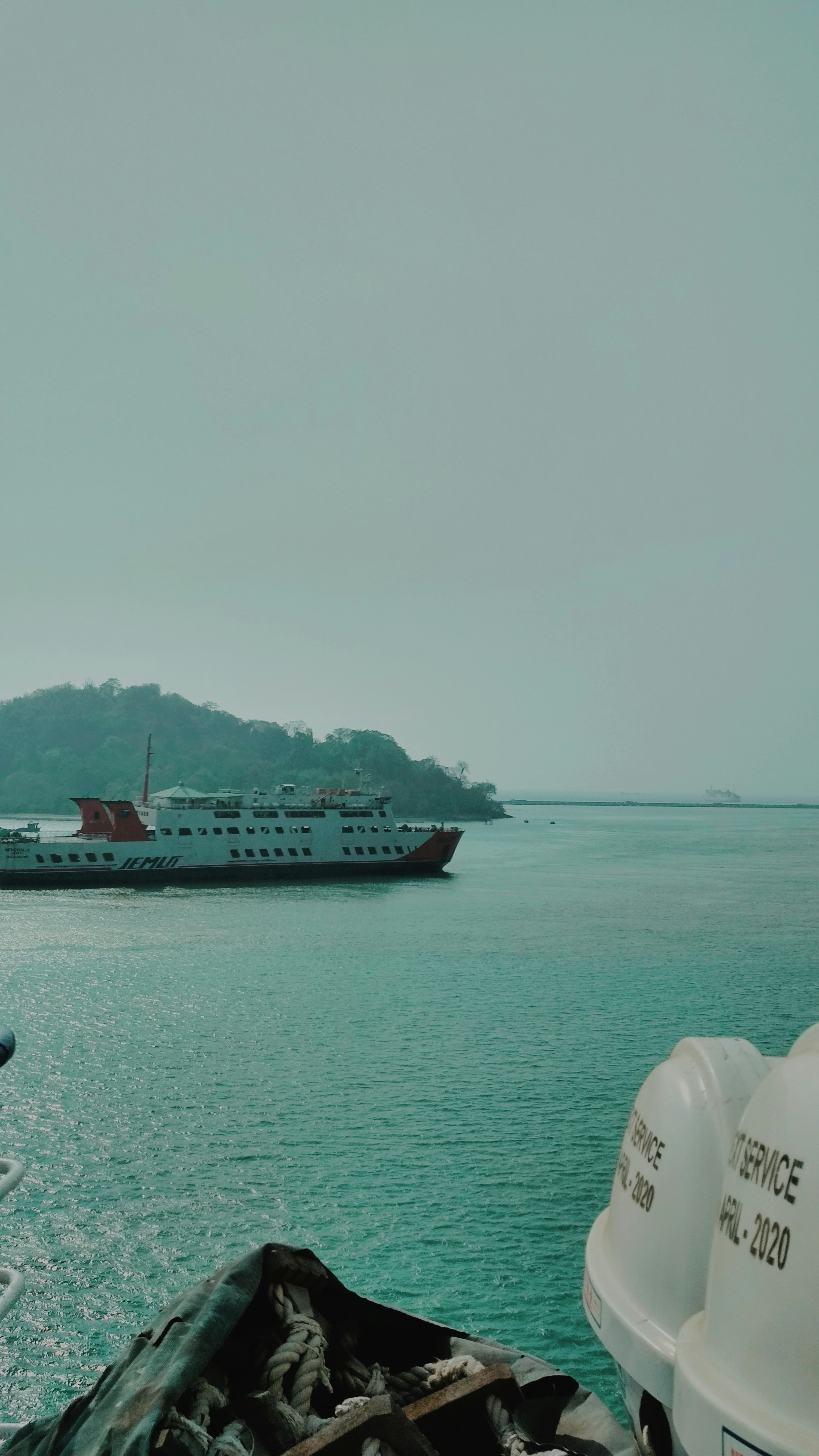 perahu besar di air dekat pulau kecil