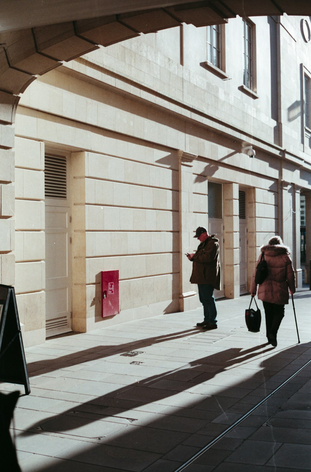 Un par de personas caminando por una calle