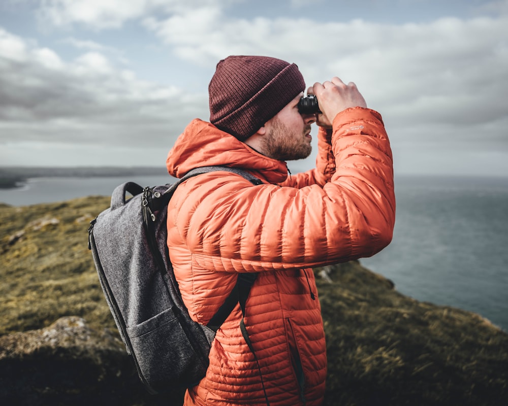 a man with a backpack looking through binoculars