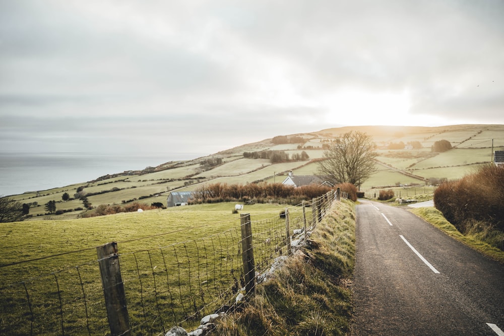 a country road with a fence on the side of it