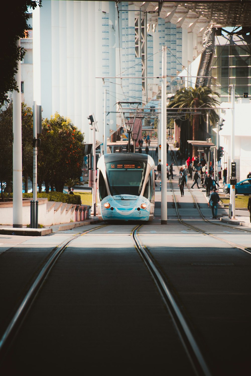 a white and blue train traveling down train tracks