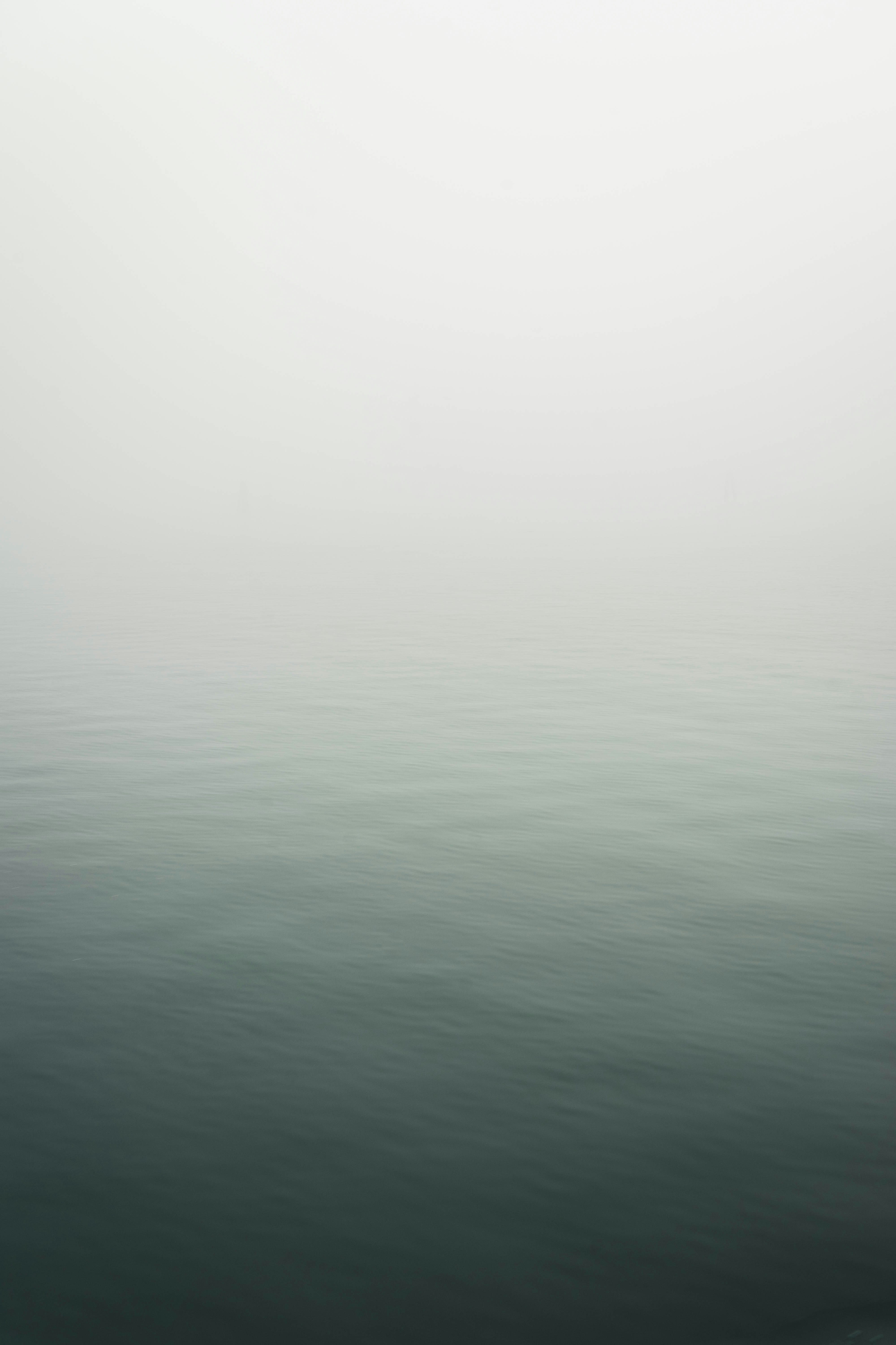 a large body of water surrounded by fog