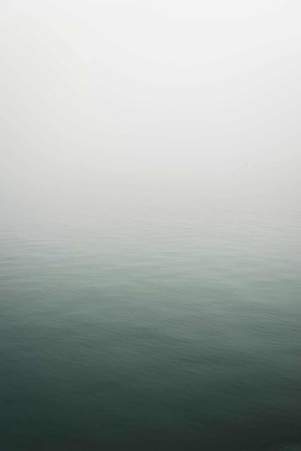 a large body of water surrounded by fog