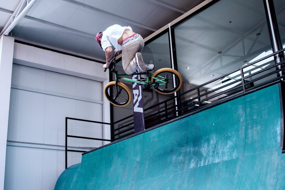 a man riding a bike up the side of a ramp