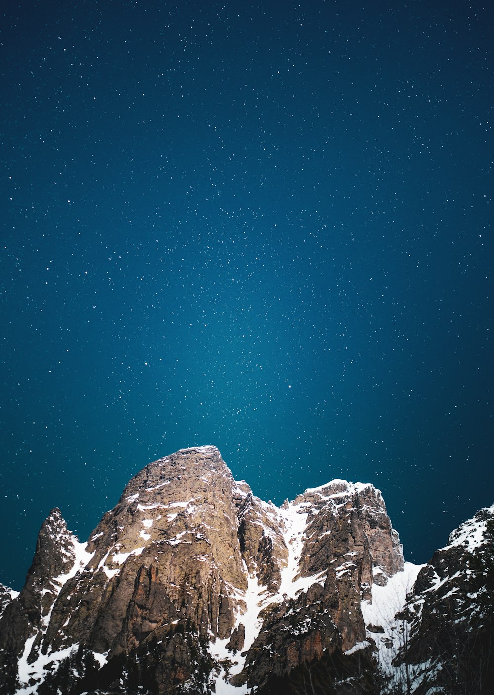 the night sky over a snowy mountain range