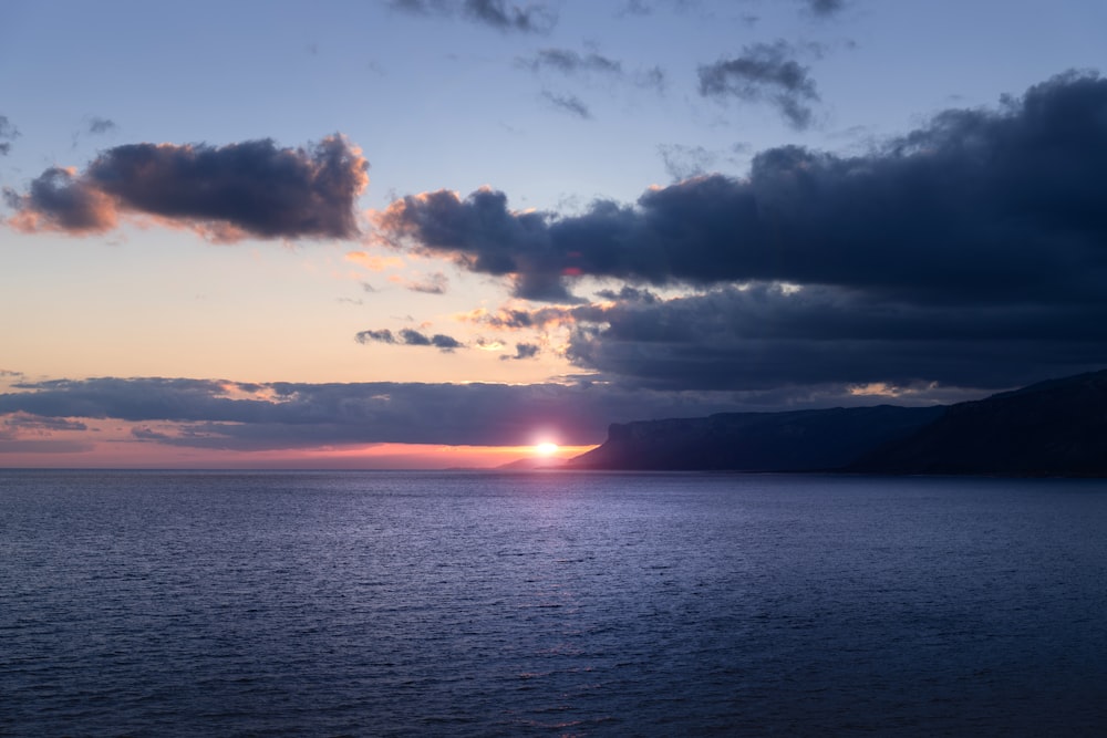 a large body of water under a cloudy sky