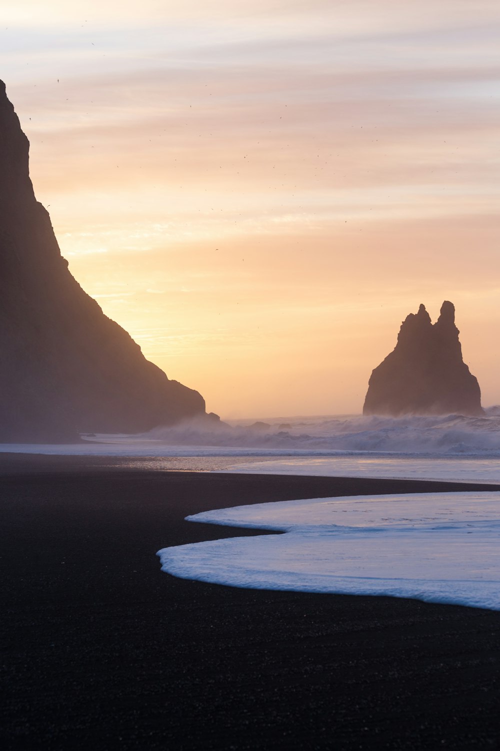 a couple of large rocks sitting on top of a beach