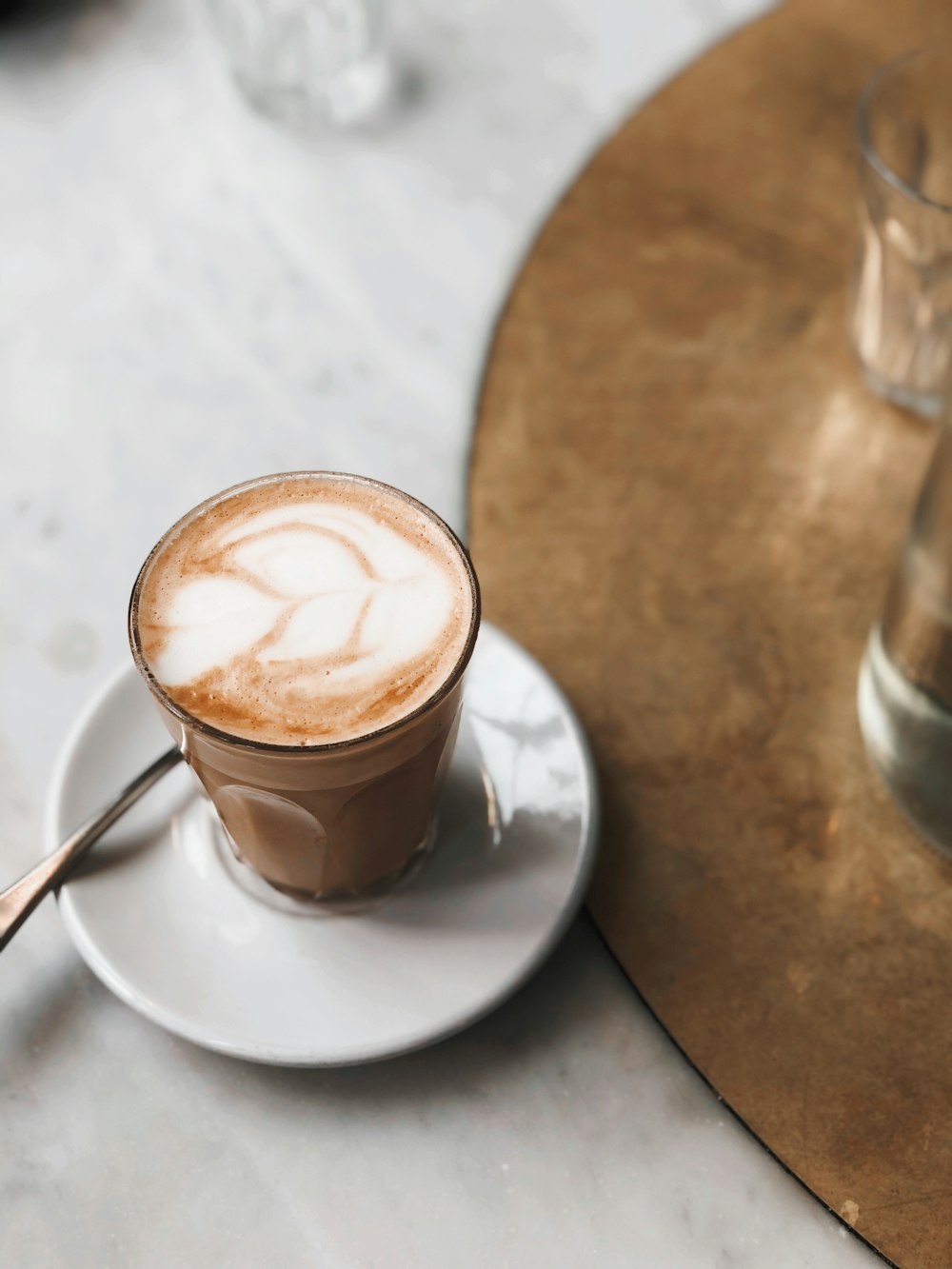 a cappuccino on a saucer with a spoon