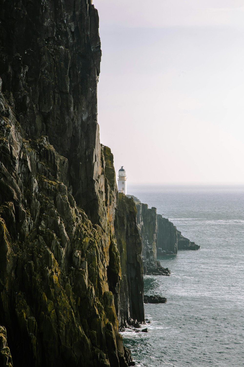 a lighthouse on a cliff overlooking the ocean