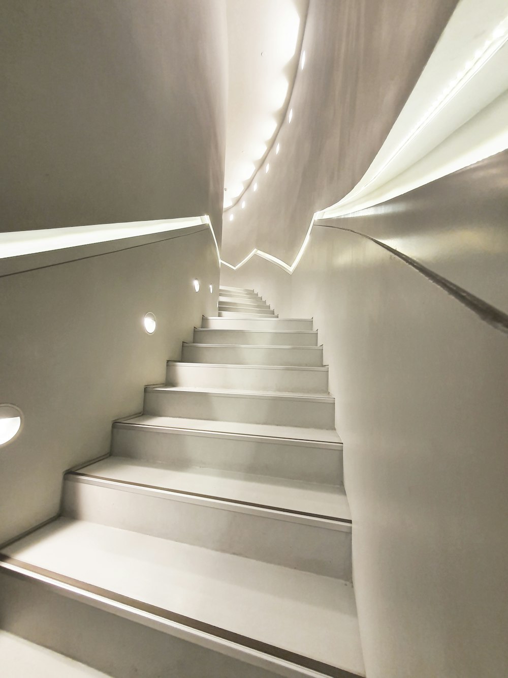 a set of white stairs leading up to a skylight