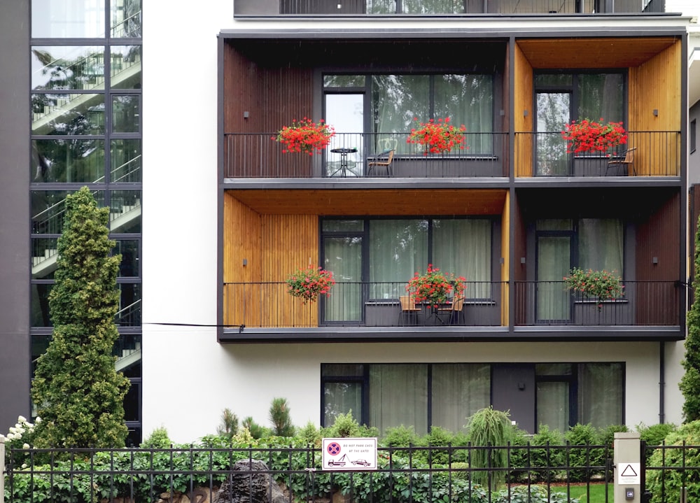 a tall building with balconies and flowers on the balconies