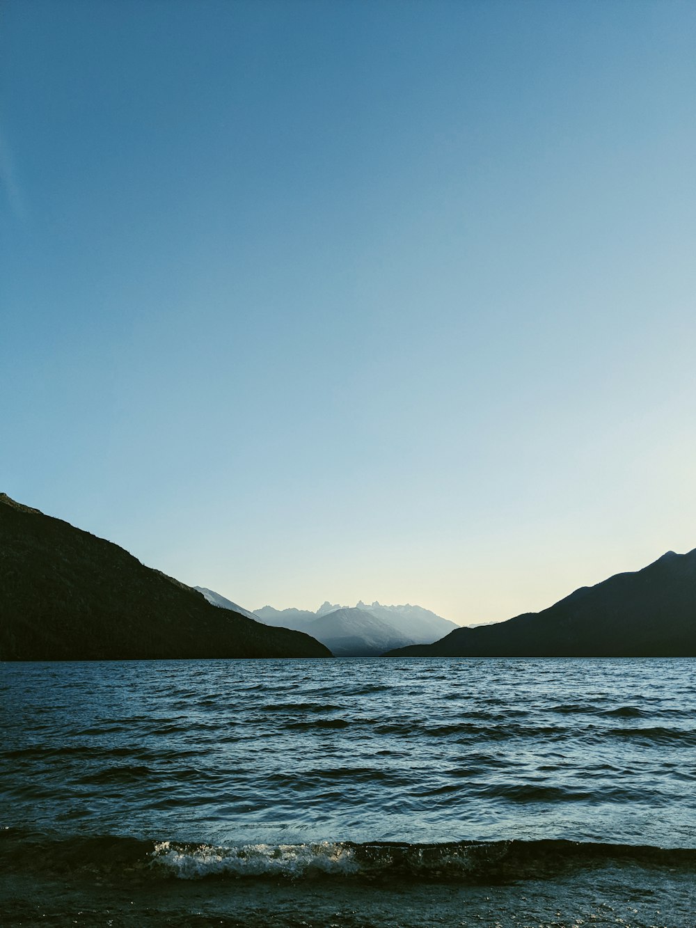 Uno specchio d'acqua con le montagne sullo sfondo