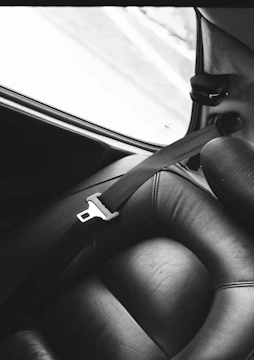 a black and white photo of a seat in a car