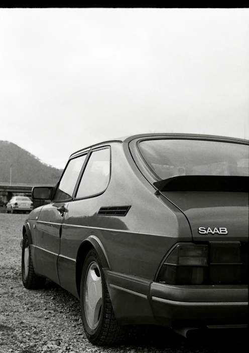 a black and white photo of a saab 900 SPG car