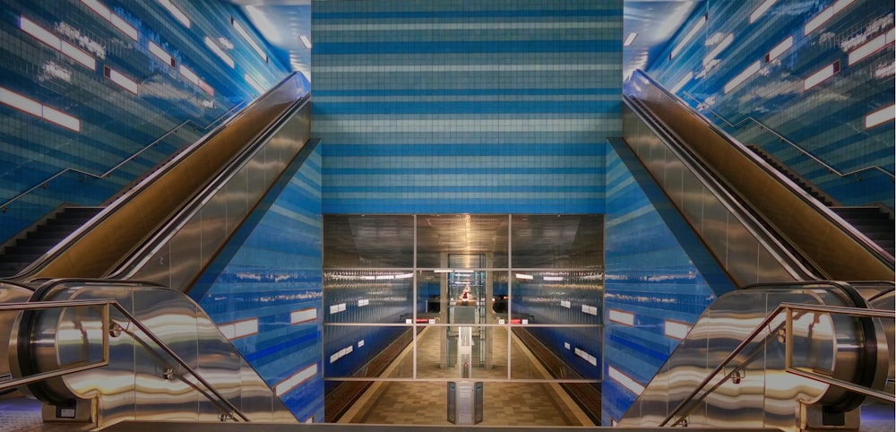 an escalator in a subway station with blue walls