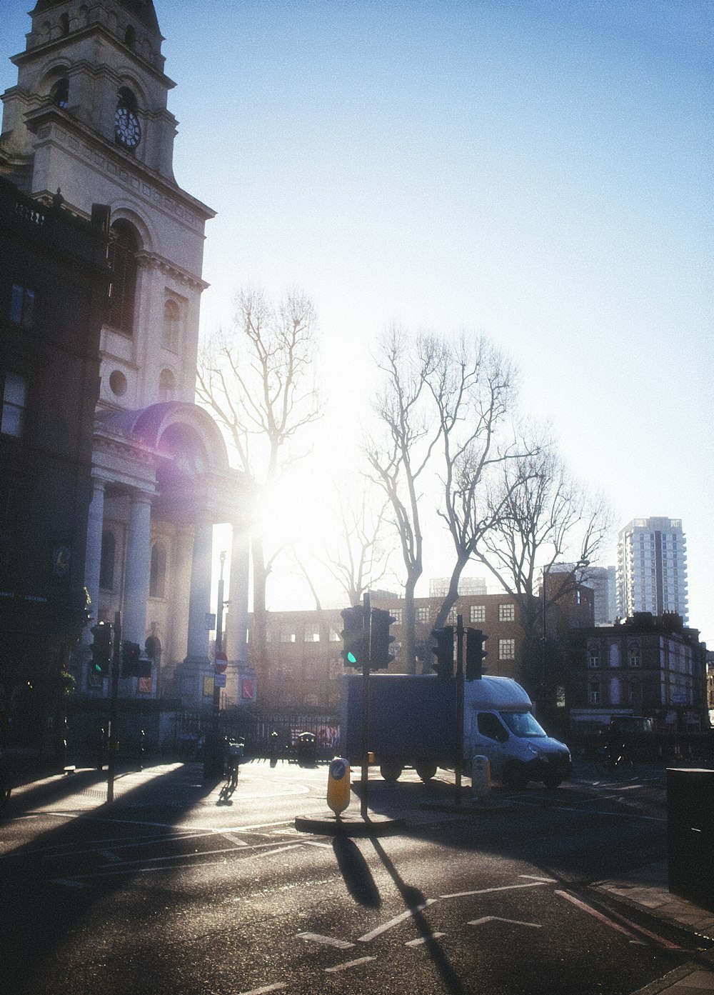 the sun is shining on a city street