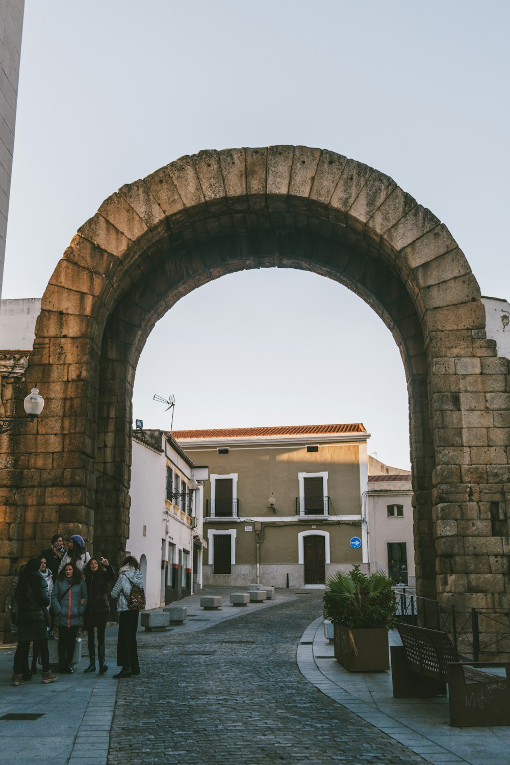 a group of people standing under a stone arch