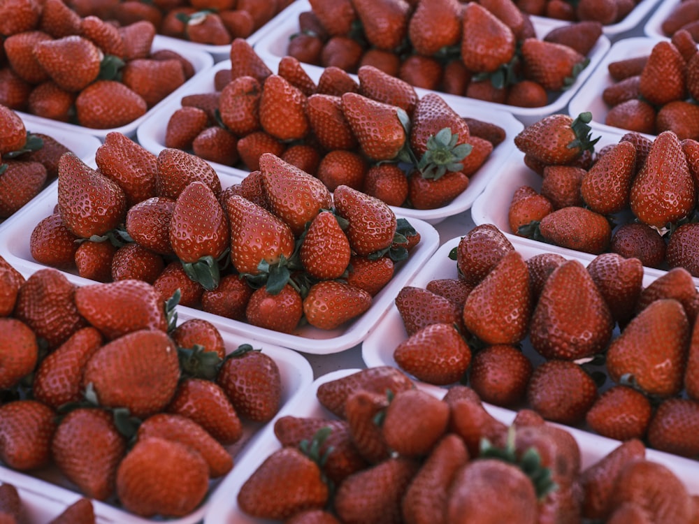 a bunch of strawberries are in trays on a table