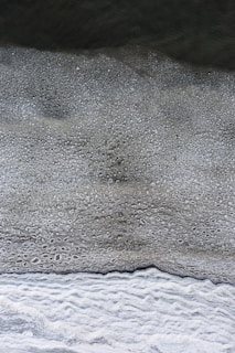 a black and white photo of water and sand