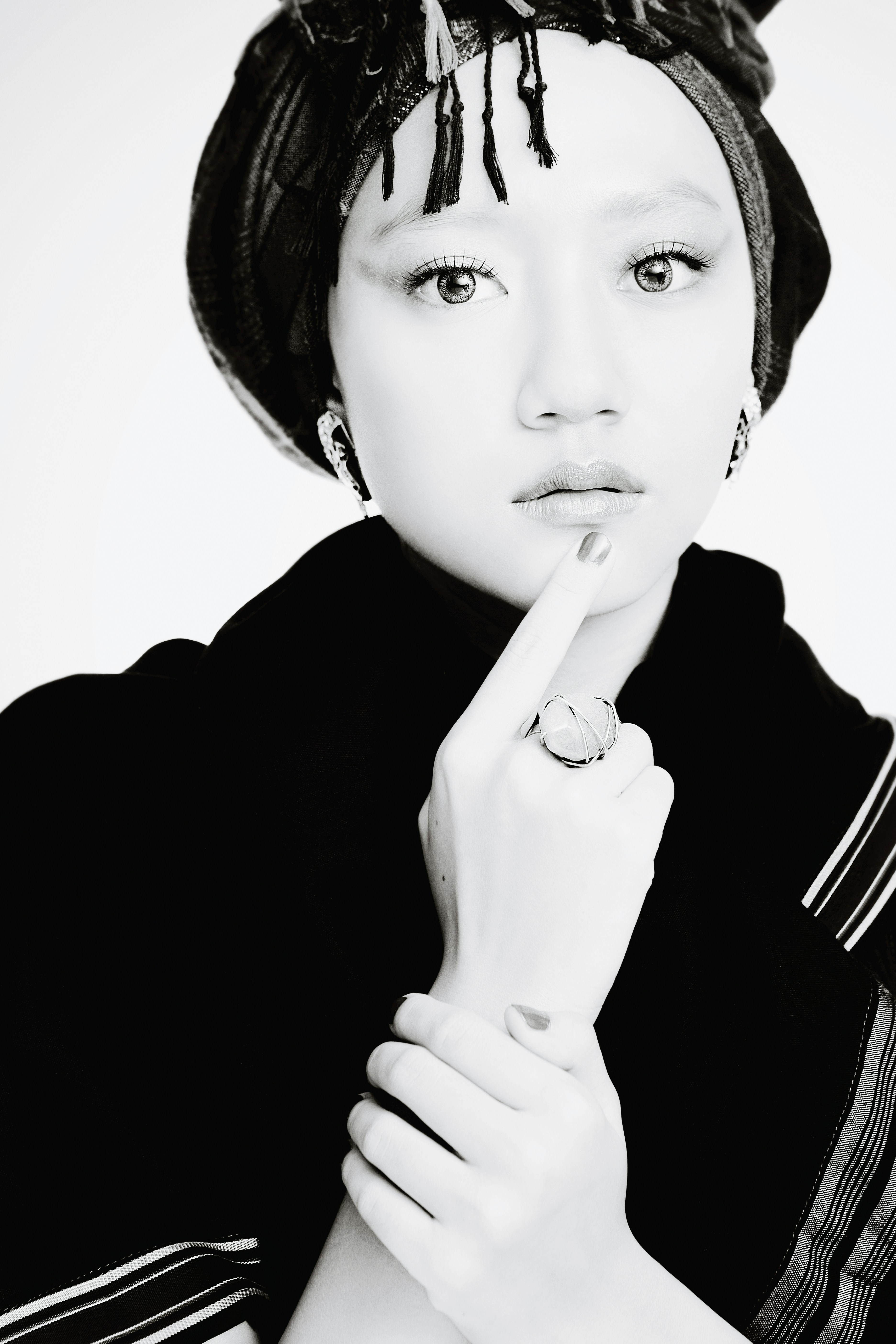 a black and white photo of a woman with a ring on her finger