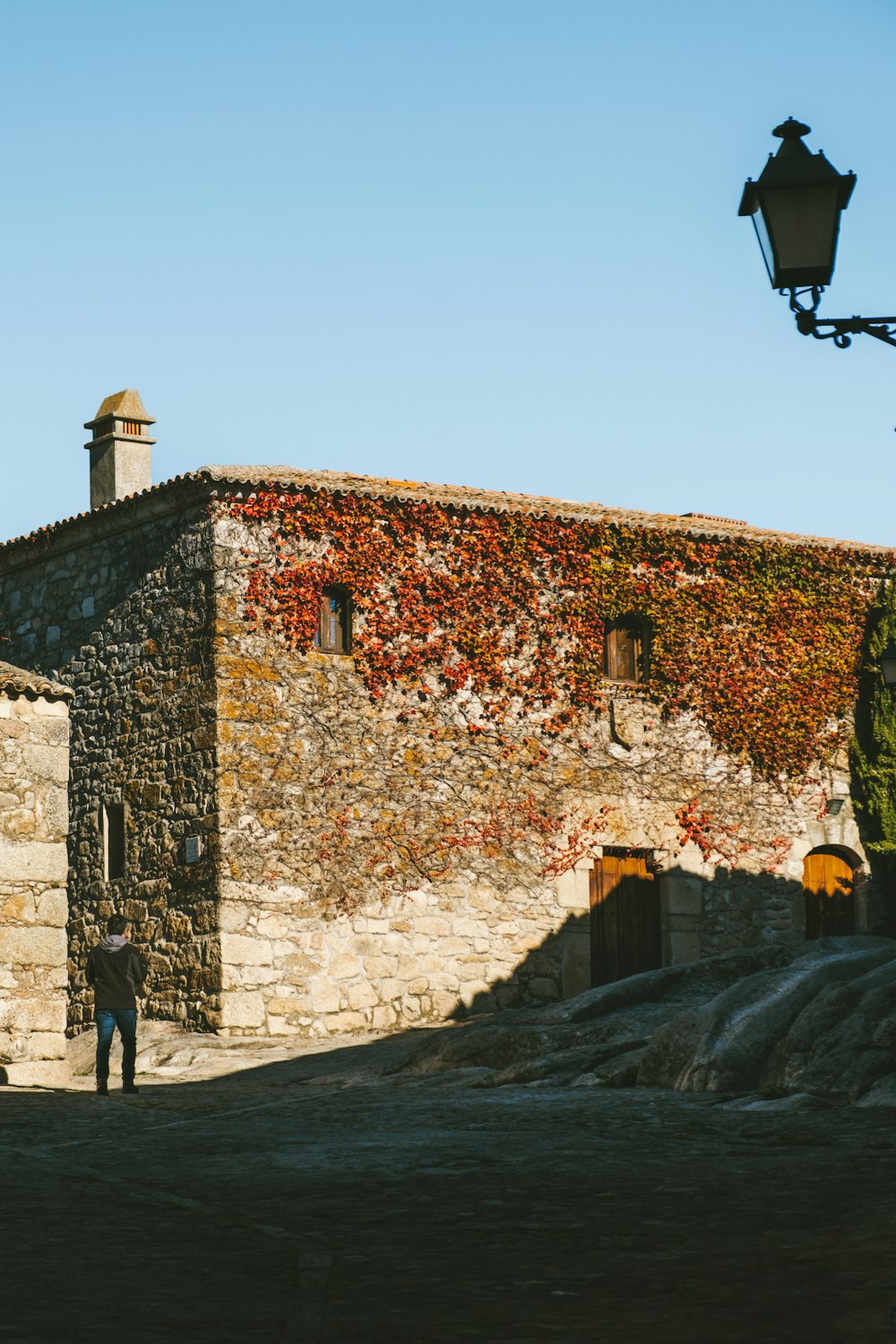 a man standing in front of a stone building