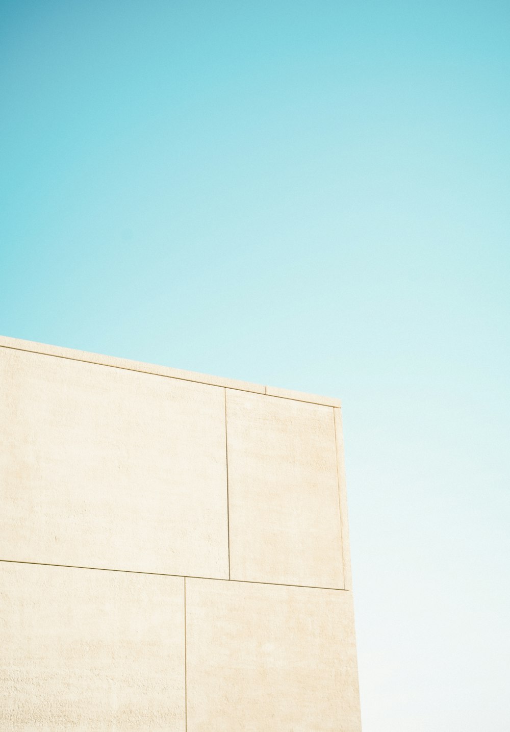 Un homme sur une planche à roulettes au sommet d’un mur de ciment