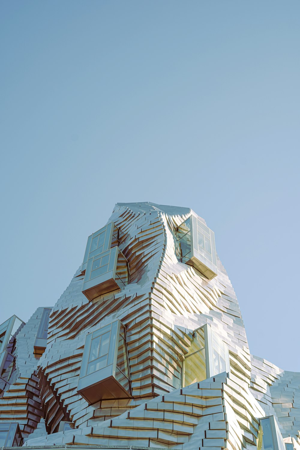 a building made of wooden planks with a blue sky in the background