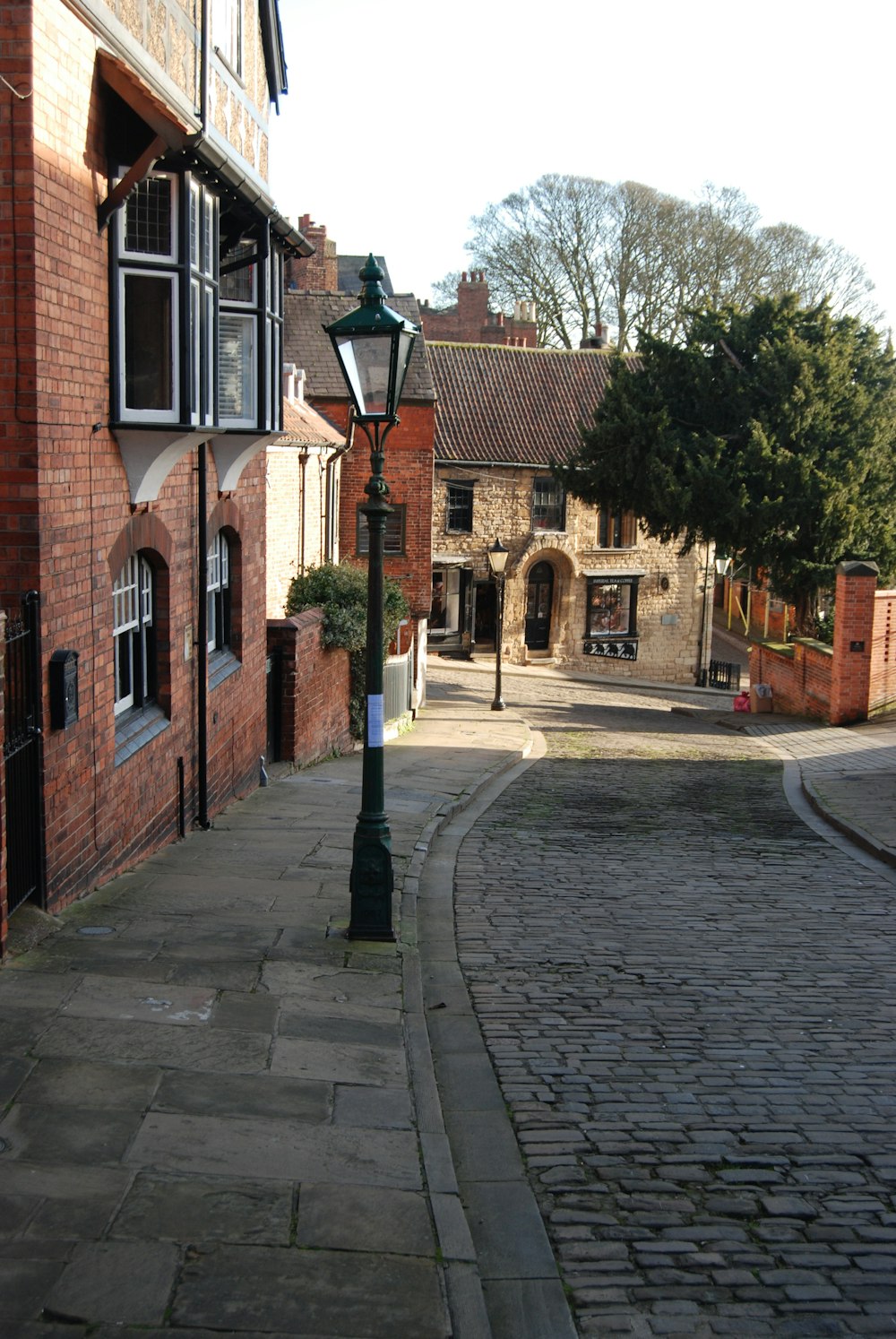 a brick street with a lamp post on the side of it