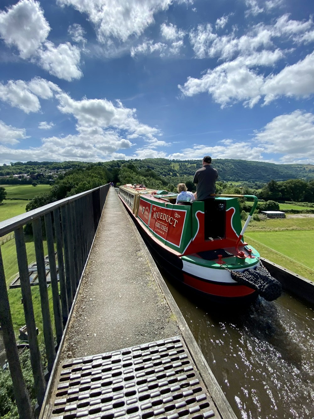 a man riding on the back of a red and green boat