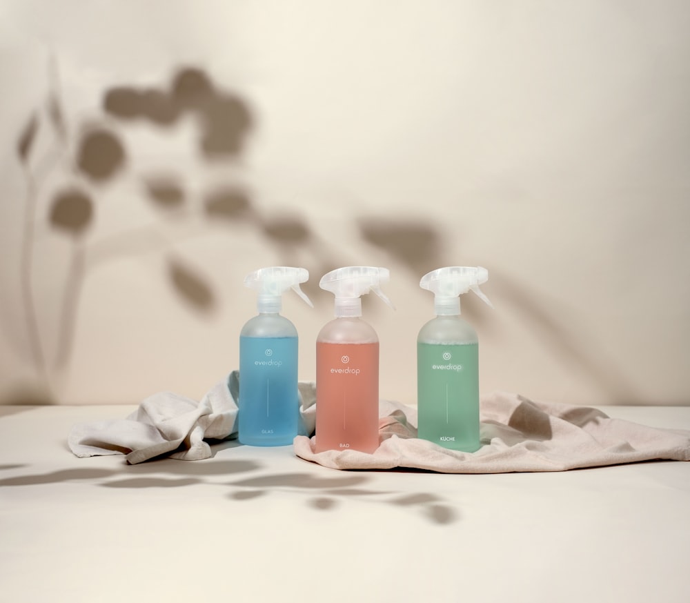 three bottles of hand sanitizers sitting on a table