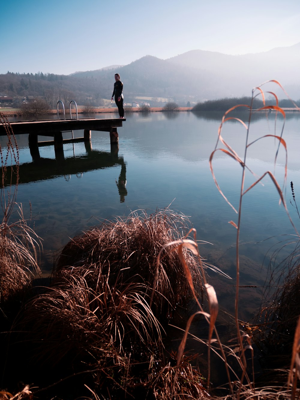 a person standing on a dock over a body of water