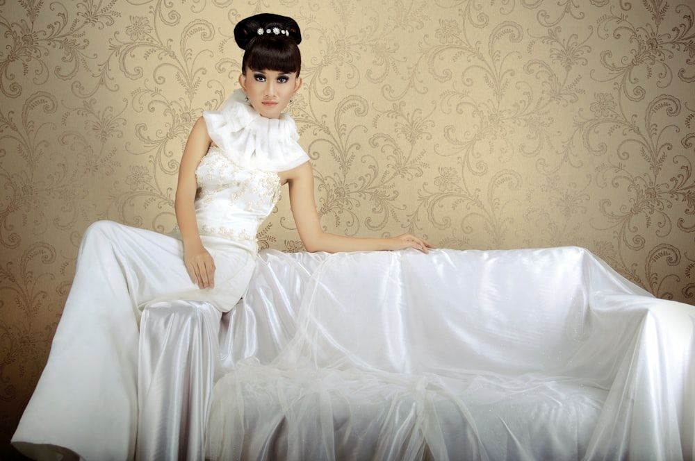 a woman sitting on top of a white couch