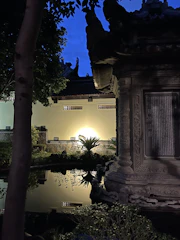 A serene landscaped garden featuring clean lines and subtle vertical light fixtures at dusk.