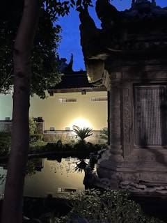 A serene garden corner featuring a stone bench, flowering plants, and soft ambient lighting at dusk.