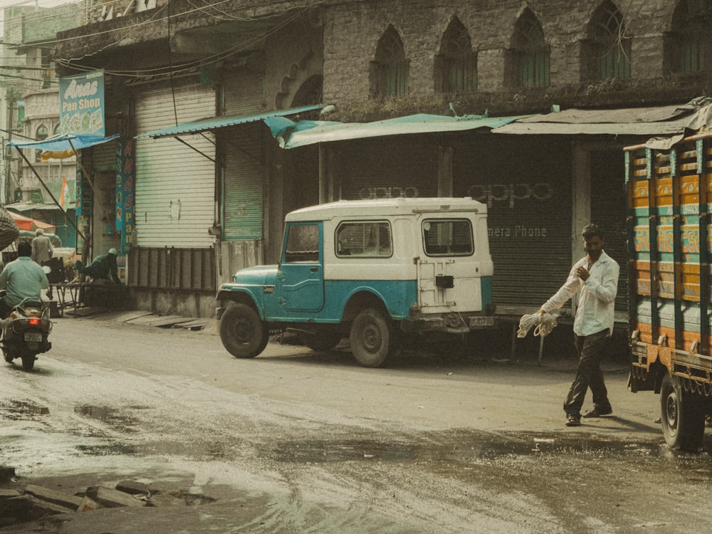 a blue and white truck driving down a street