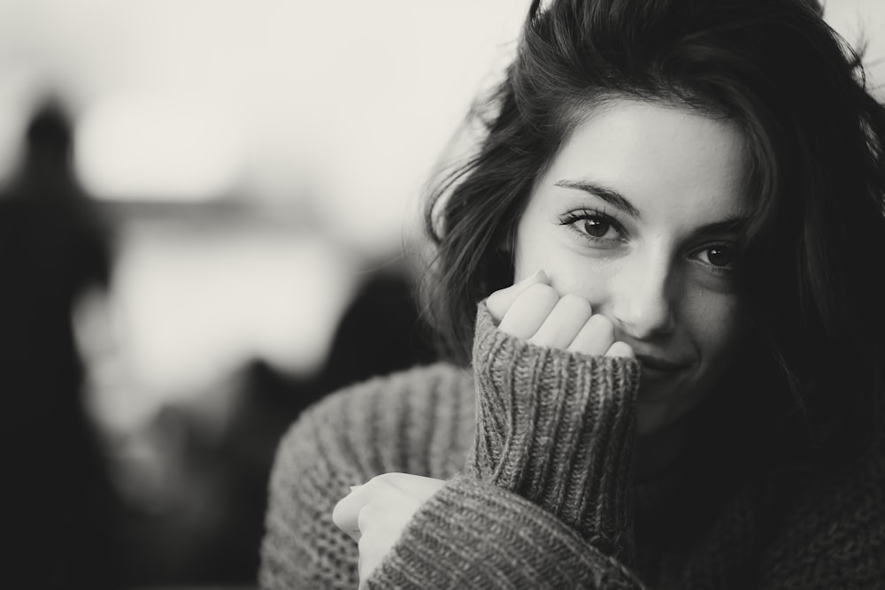 a black and white photo of a woman with her hand on her face