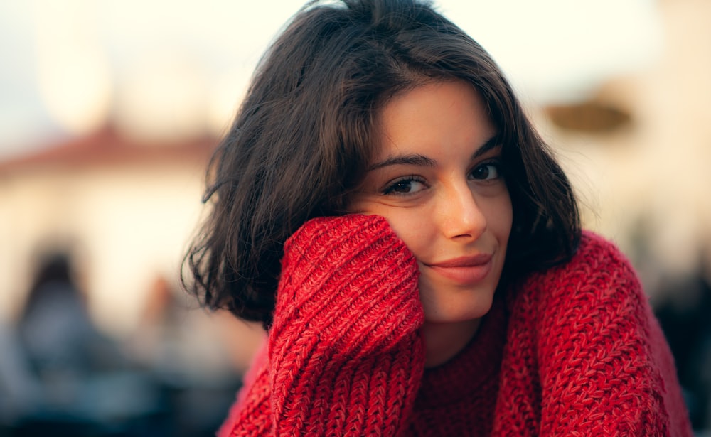 a close up of a person wearing a red sweater