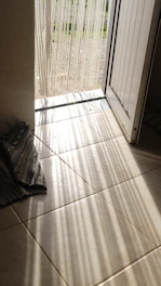 Close-up of a colorful beaded curtain hanging in a sunlit bohemian room.